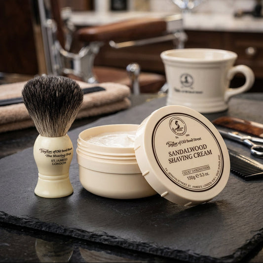 Shaving cream and brush set on a counter with a barbershop background